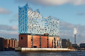 Fotografie der Elbphilharmonie in Hamburg aus Sicht von der Anlegerbrücke am Hafen.