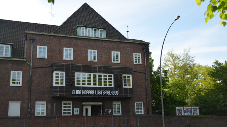 Fotografie eines Hauses in Backsteinarchitektur mit dem Schriftzug Alma Hoppes Lustspielhaus.